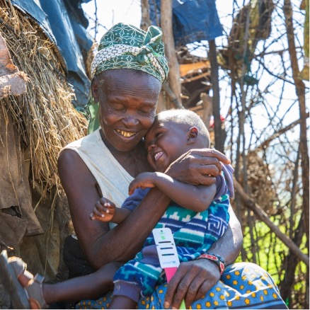 Woman cuddles her grandchild.