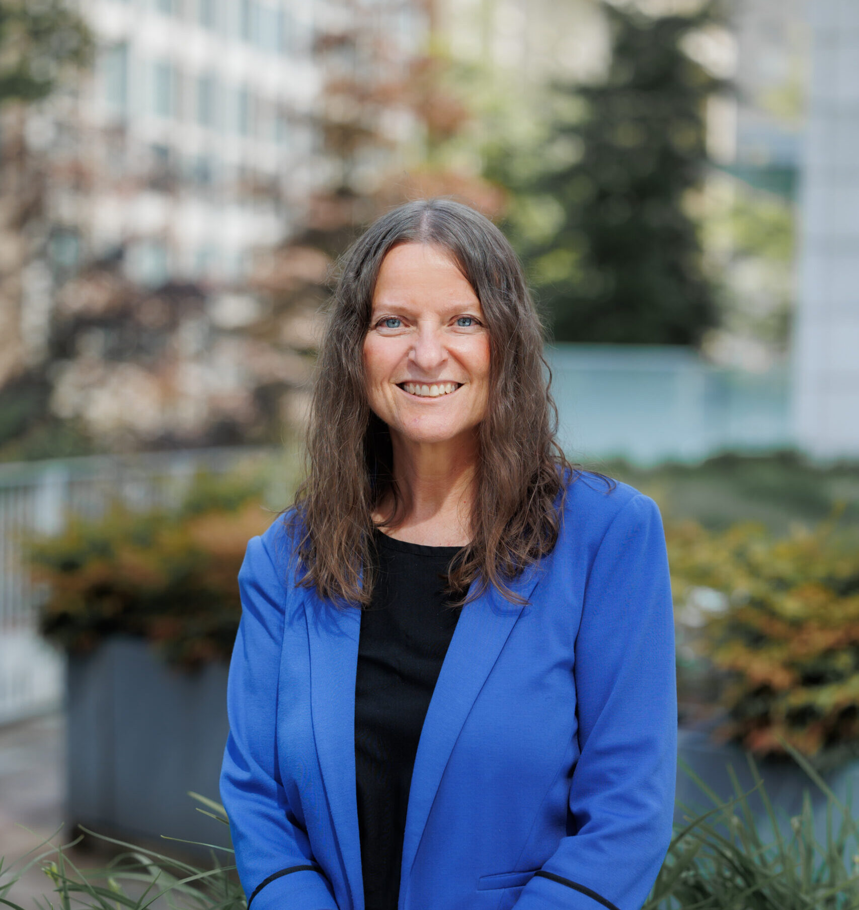 Gwen standing in front of a city scape.