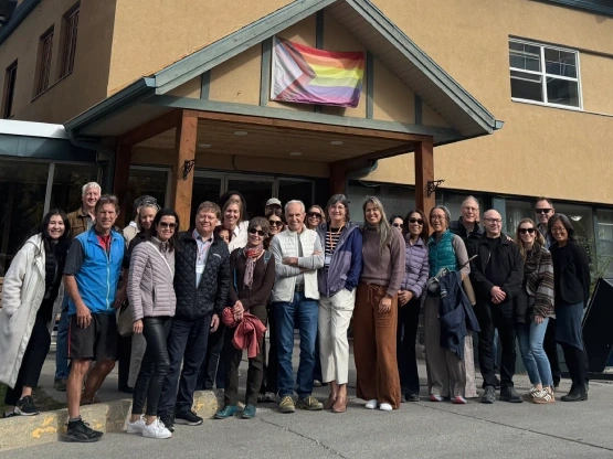 A group of people pose for a photo with the Intersectional pride flag.